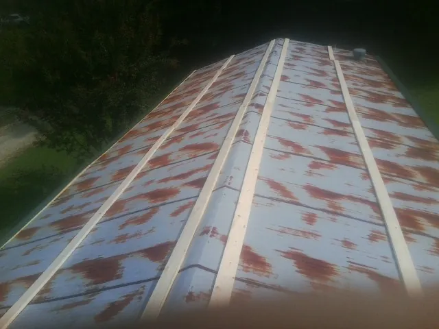 Rusted metal roof panels with new wood purlins before replacement — Storm Damage Roof Repair in Woonsocket by Roofing Brothers
